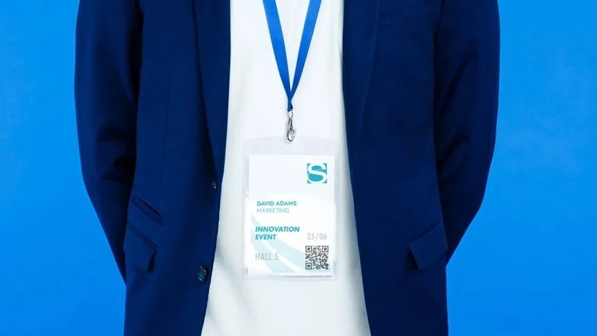 Ένας άνδρας με μπλε κοστούμι με κορδόνι με σήμα στο λαιμό του