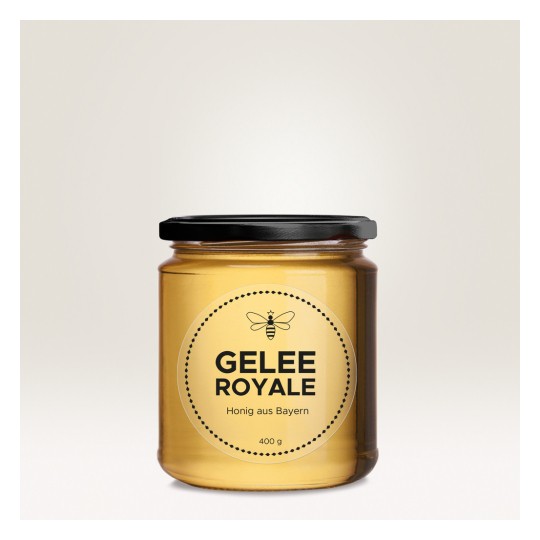 Η εικόνα δείχνει ένα βαζάκι Gelee Royale, ένα προϊόν μέλισσας, με ετικέτα που δείχνει ότι είναι μέλι από τη Βαυαρία. Το βαζάκι είναι διαφανές με μαύρο καπάκι και περιέχει 400 γραμμάρια.