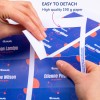 Η εικόνα δείχνει χέρια που αποσπούν ένα τμήμα από ένα υψηλής ποιότητας εκτυπωμένο χαρτί στο οποίο αναγράφονται ονόματα και ρόλοι. Το φόντο έχει ένα ζωντανό σχέδιο με στοιχεία σε μπλε και κόκκινο χρώμα.